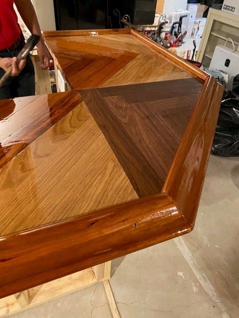 a person is painting a wooden table with a hammer