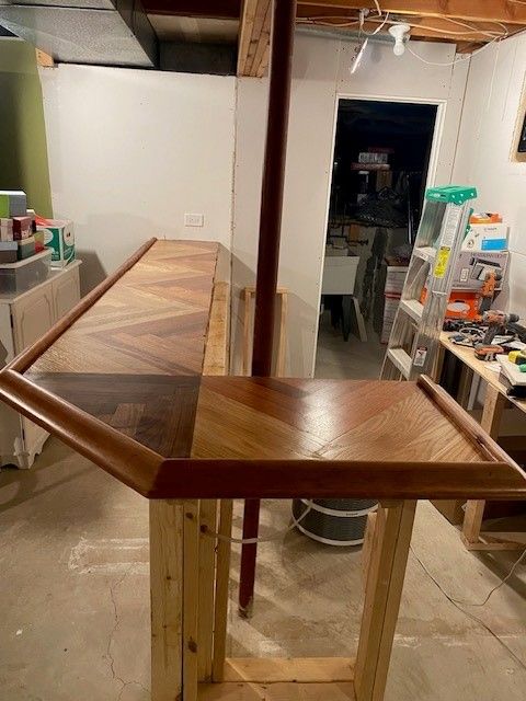 a wooden table is sitting in a room next to a ladder 