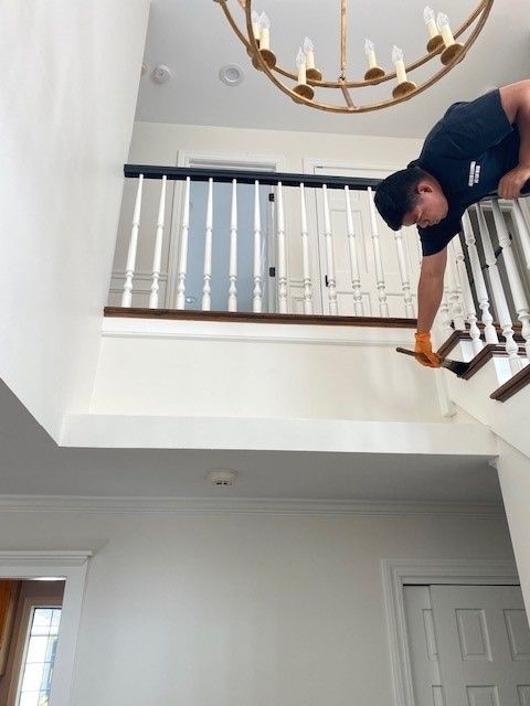 a man is painting the railing of a staircase