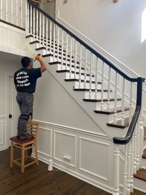 a man standing on a chair cleaning a staircase