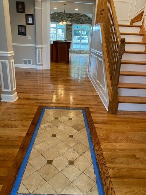 a hallway with hardwood floors and stairs in a house 