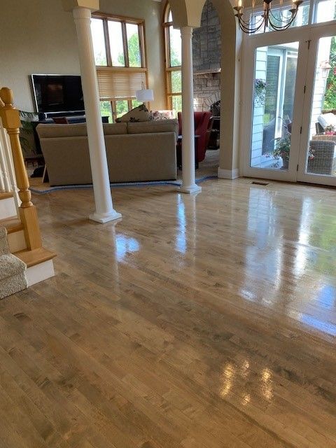 a living room with hardwood floors, a couch, stairs, and a television