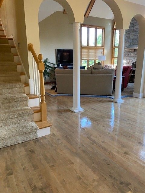a living room with hardwood floors and stairs leading up to it