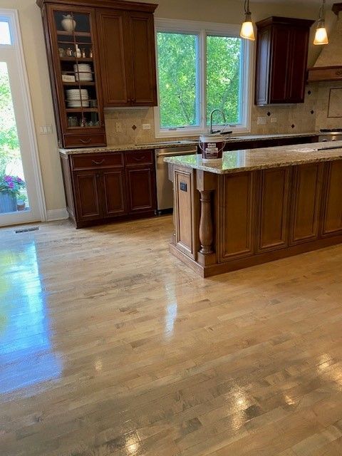 a kitchen with wooden cabinets, granite counter tops, and a large island