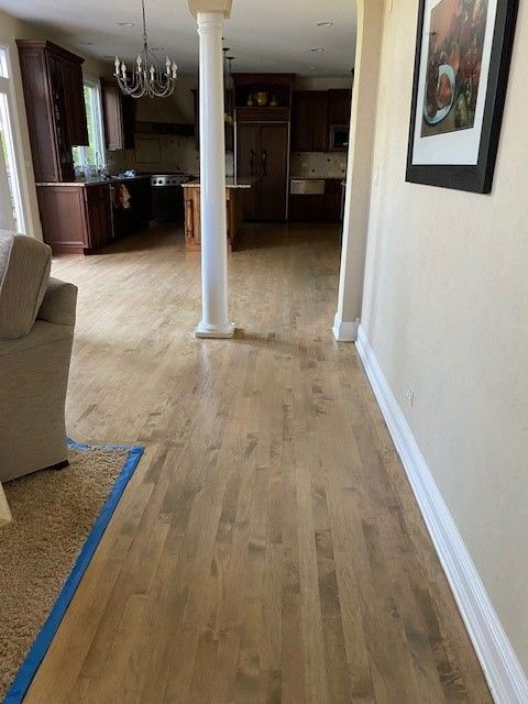 a hallway in a house with hardwood floors and a picture on the wall
