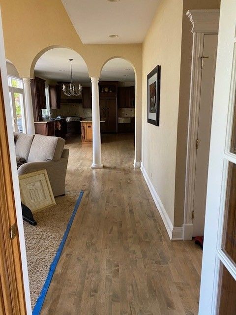 a hallway in a house with hardwood floors and a couch 