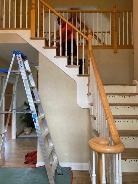 a person standing on top of a staircase next to a ladder
