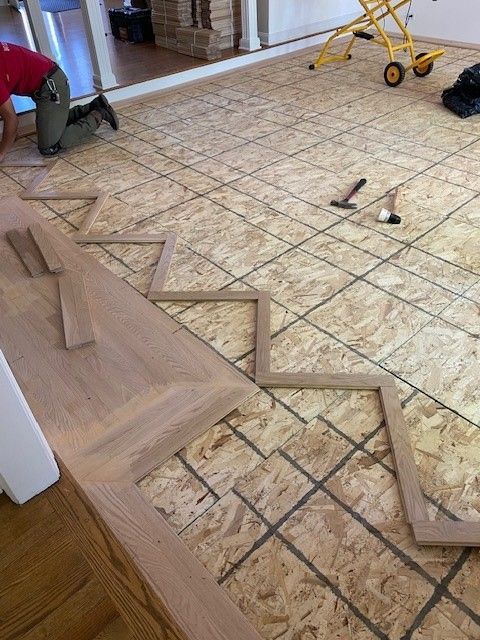 a man is kneeling on a wooden floor in a room.