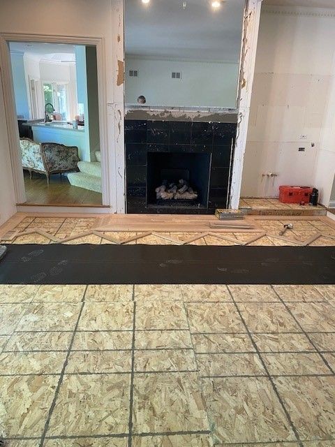 a living room with a fireplace and tile floor.