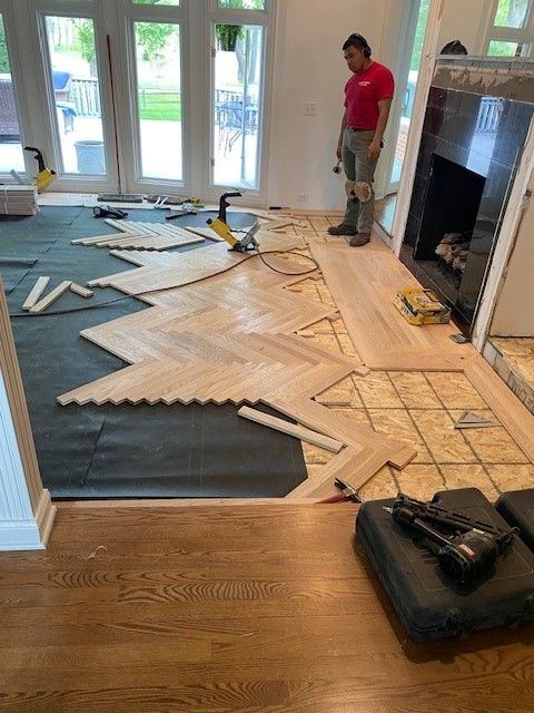 a man is standing on a wooden floor in a living room.