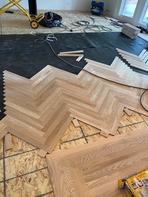a wooden floor is being installed in a herringbone pattern.