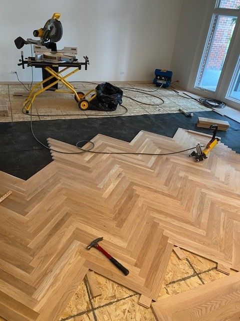 a wooden floor is being installed in a herringbone pattern.