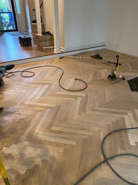 a wooden floor with a herringbone pattern is being installed in a room.