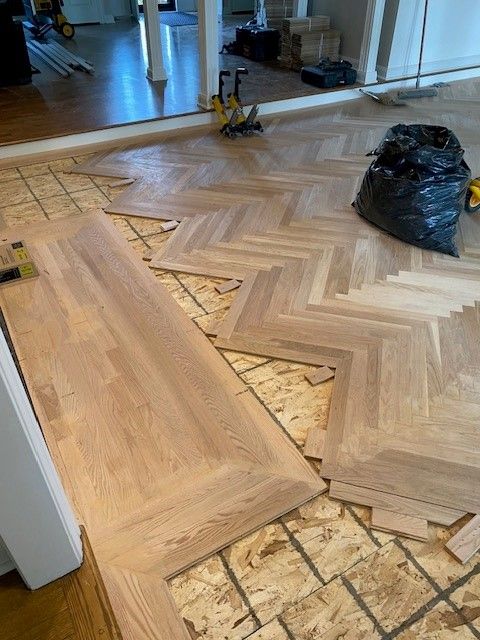 a wooden floor is being installed in a herringbone pattern.
