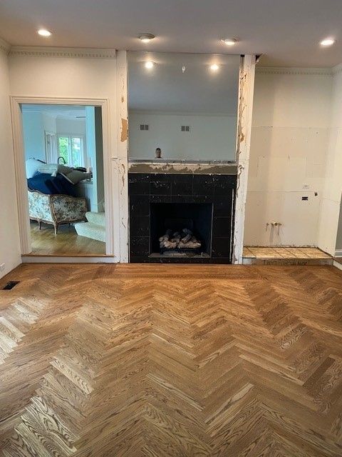 a living room with a fireplace and a wooden floor.