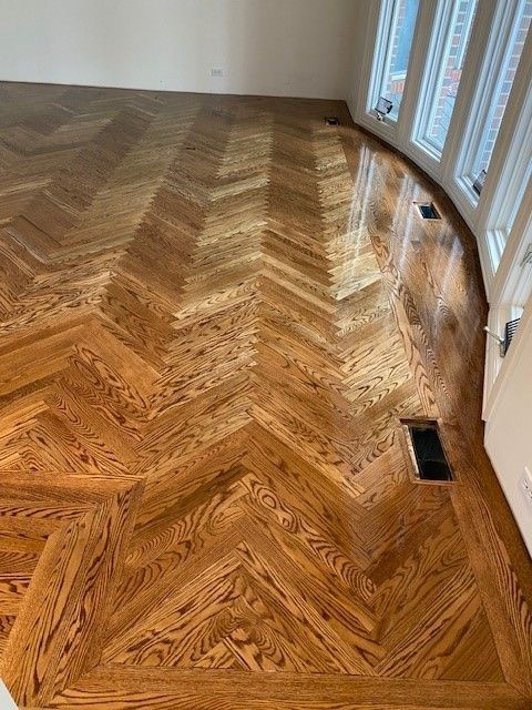 a wooden floor with a herringbone pattern in the living room.