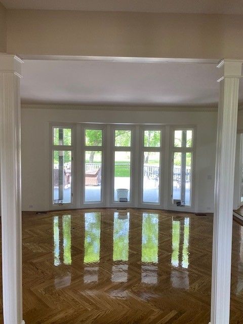 a large empty room with a wooden floor and lots of windows.