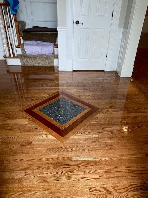a wooden floor with a square in the middle of it in a hallway.