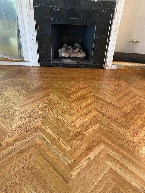 a living room with a wooden floor and a fireplace.