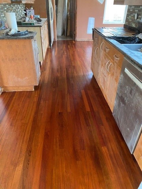 a kitchen with hardwood floors and stainless steel appliances.