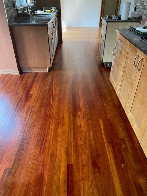 a kitchen with hardwood floors and stainless steel cabinets.