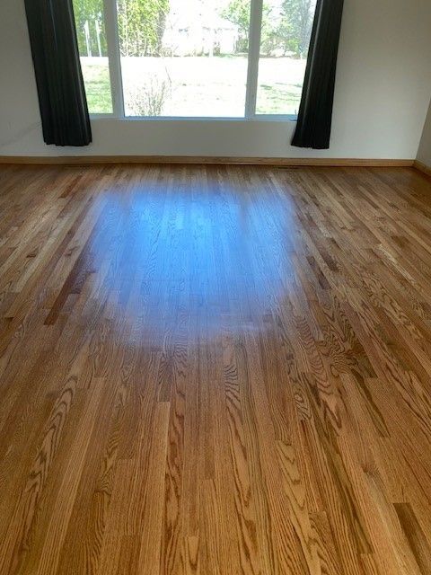a living room with hardwood floors and a window.