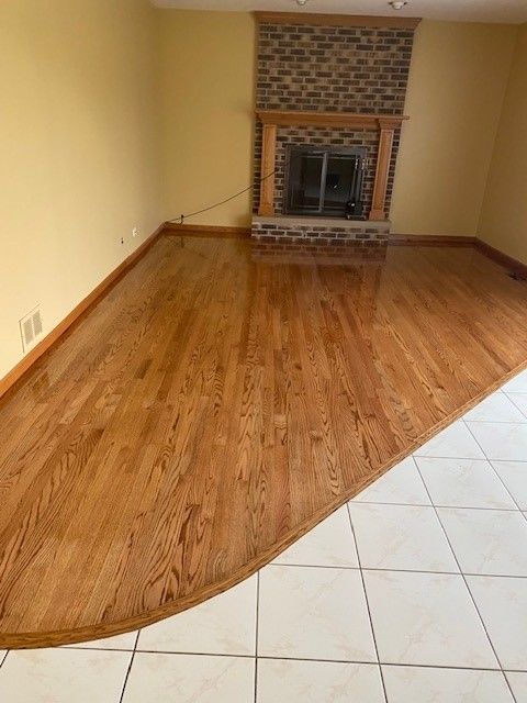 a living room with hardwood floors and a fireplace.