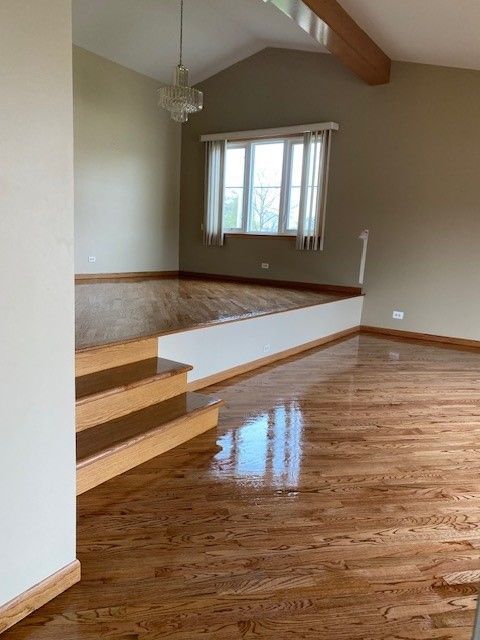 an empty living room with hardwood floors and stairs
