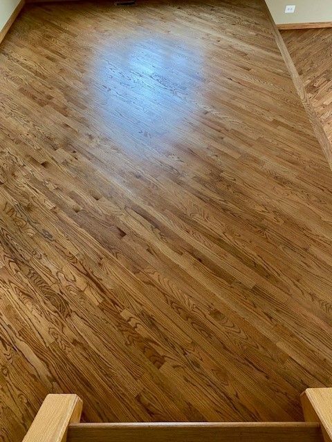 a room with a wooden floor and stairs leading up to it.