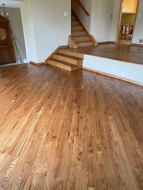 a living room with hardwood floors and stairs.