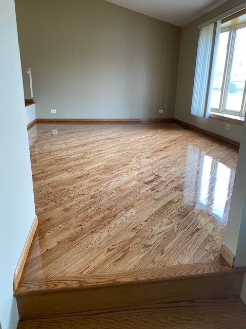 an empty living room with hardwood floors and stairs.