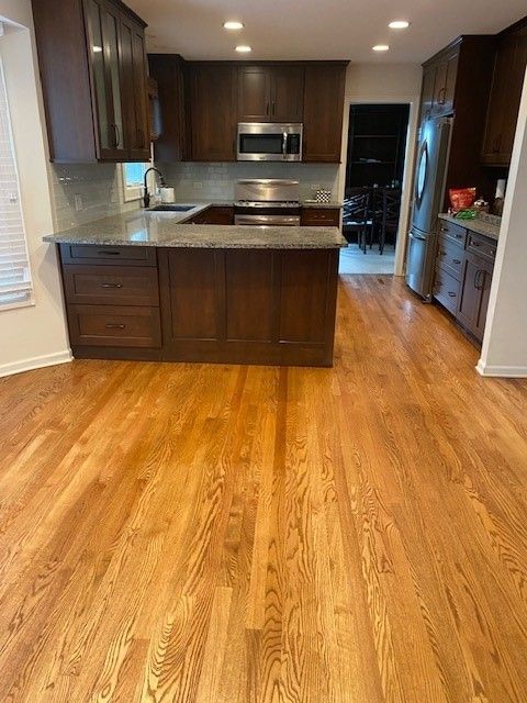 a kitchen with hardwood floors and stainless steel appliances .