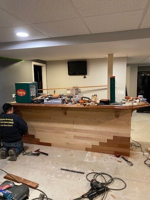 a man is working on a wooden counter in a room.