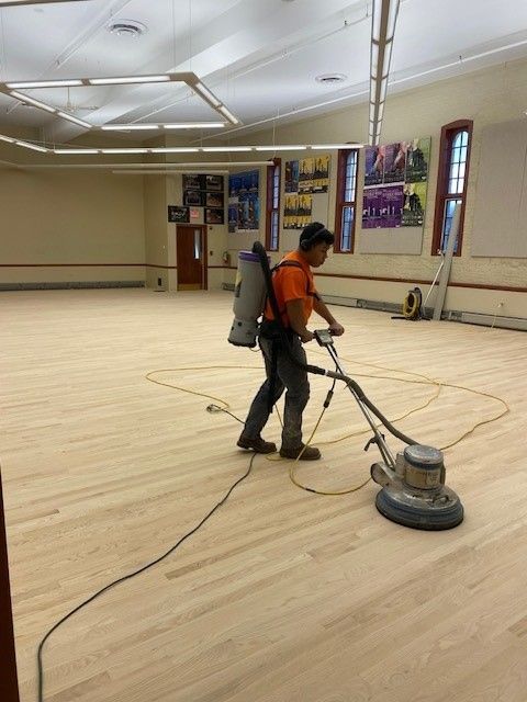 a man is polishing a wooden floor with a machine