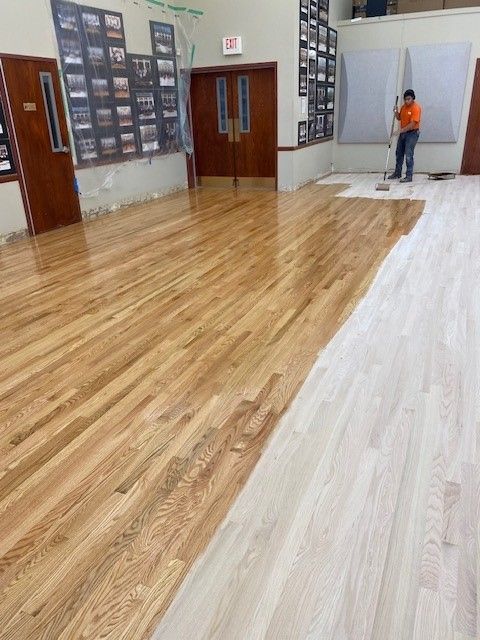 a man is painting a wooden floor in a room.