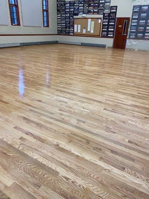 a large room with a wooden floor and a bulletin board 