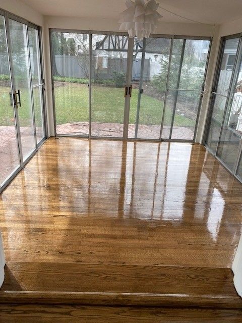 a large room with hardwood floors and sliding glass doors.
