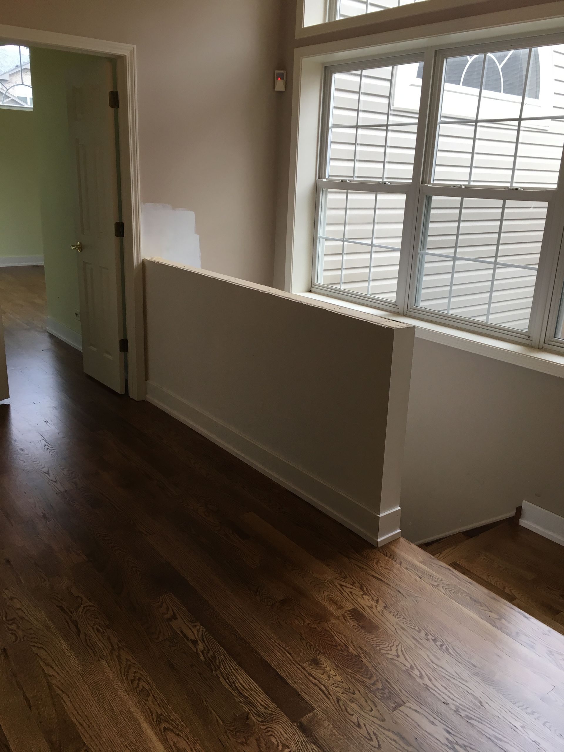 an empty room with hardwood floors and a large window