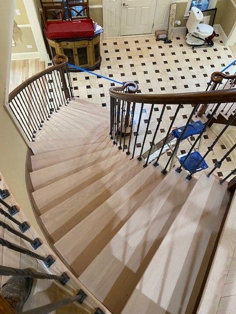 a spiral staircase with a wrought iron railing and a tiled floor