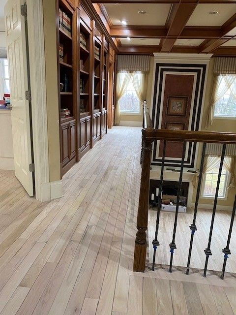 a hallway with wooden floors and a staircase in a house 