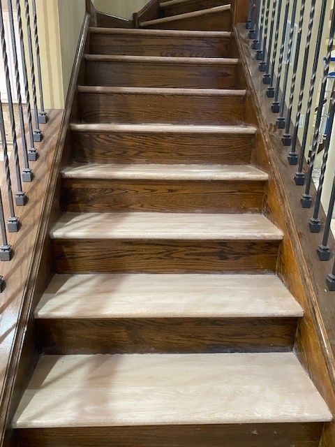 a close-up of a wooden staircase with a metal railing.