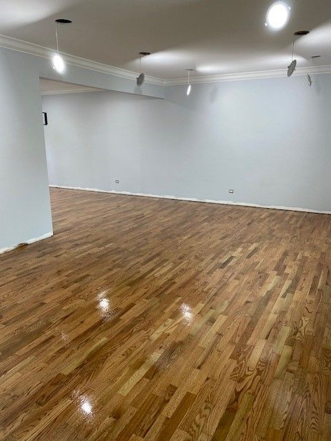 a large empty room with hardwood floors and white walls.