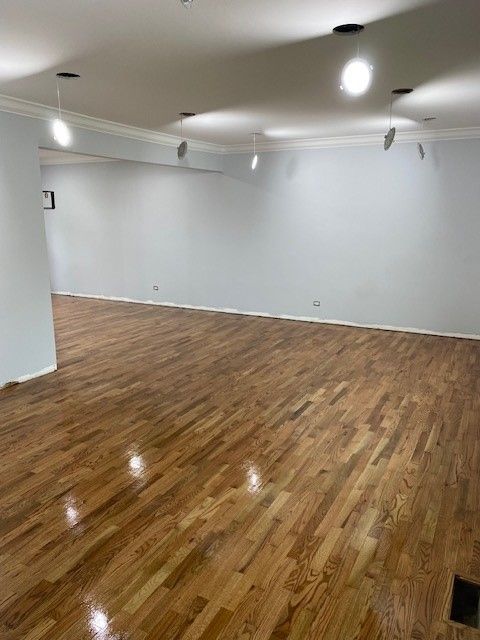 a large empty room with hardwood floors and white walls