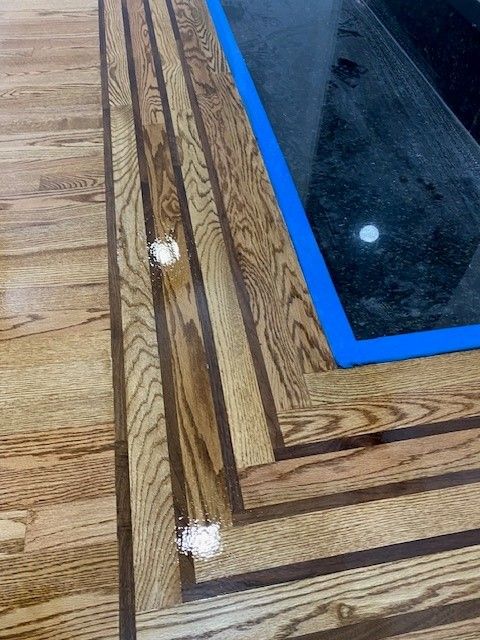 a close-up of a wooden floor with a blue tape around it.