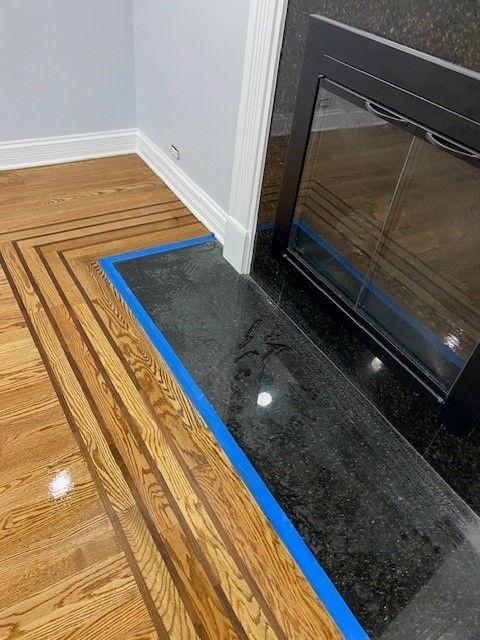 a fireplace with a wooden floor and a blue tape around it.