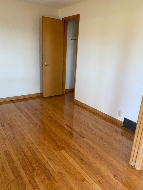 an empty room with hardwood floors and white walls.