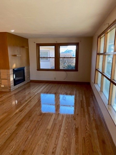 an empty living room with hardwood floors and a fireplace.