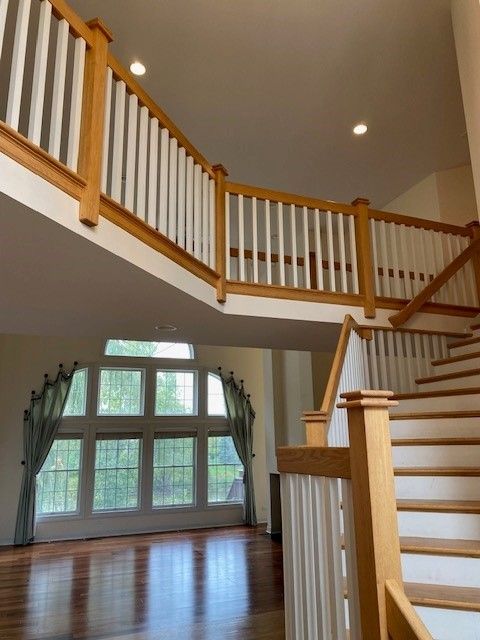 an empty house with stairs and a balcony