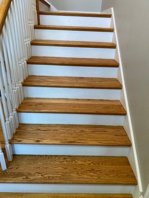 a set of stairs with wooden steps and white railings.