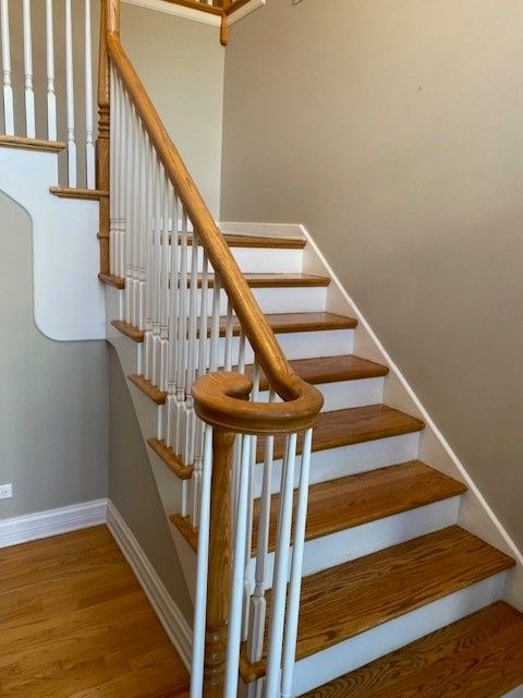 a staircase with wooden steps and white railings in a house.